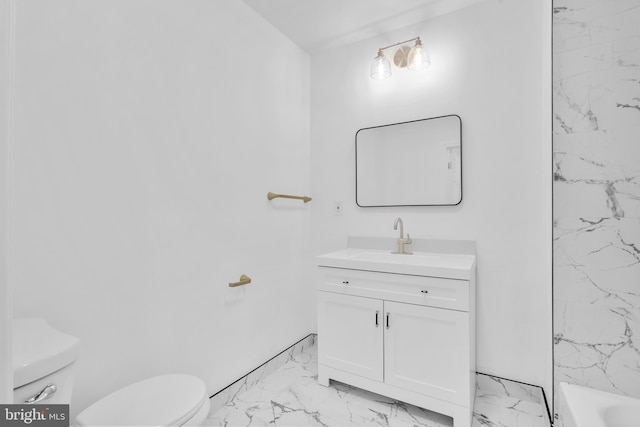 bathroom with toilet, marble finish floor, and vanity