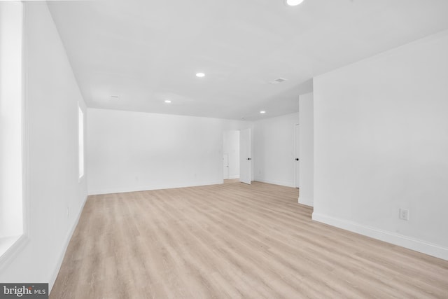 spare room with recessed lighting, light wood-type flooring, and baseboards