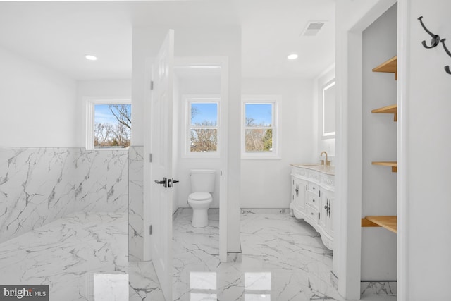 bathroom with visible vents, marble finish floor, a healthy amount of sunlight, and toilet