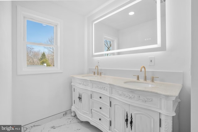 bathroom featuring a sink, marble finish floor, and double vanity