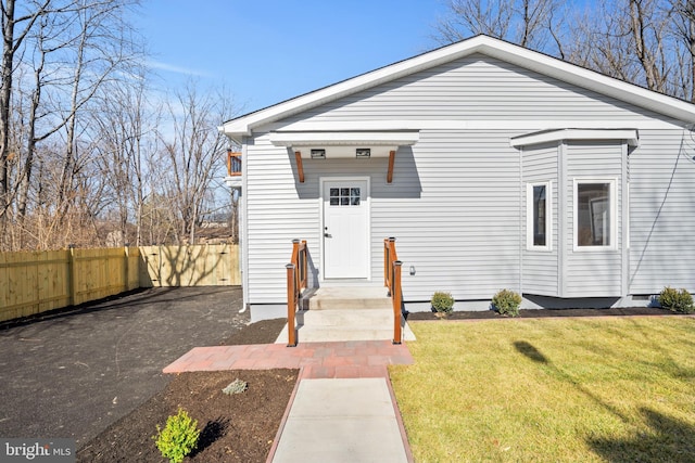 view of front of property with a front lawn and fence