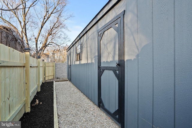 view of side of home with an outbuilding and a fenced backyard