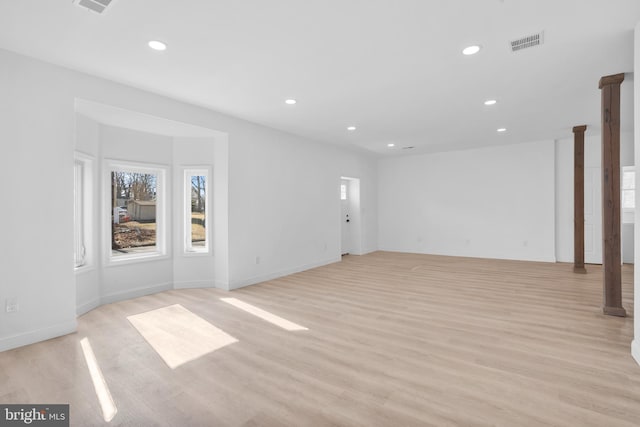 unfurnished living room with light wood-type flooring, visible vents, baseboards, and recessed lighting