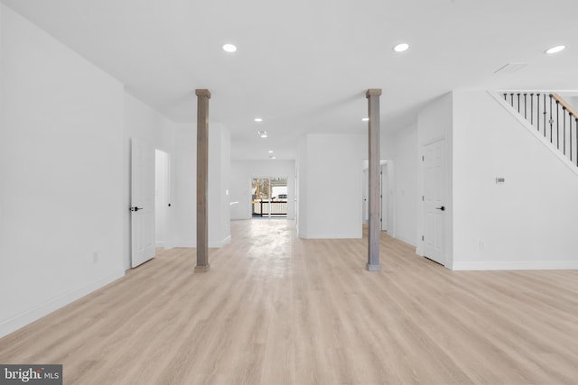 unfurnished living room with recessed lighting, stairway, baseboards, and light wood-style flooring