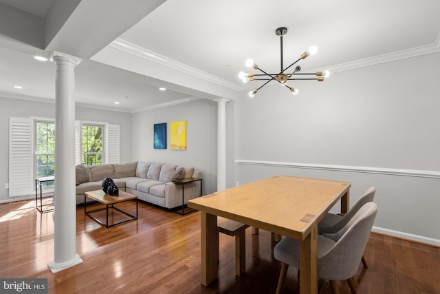 dining space featuring ornamental molding, ornate columns, and wood finished floors