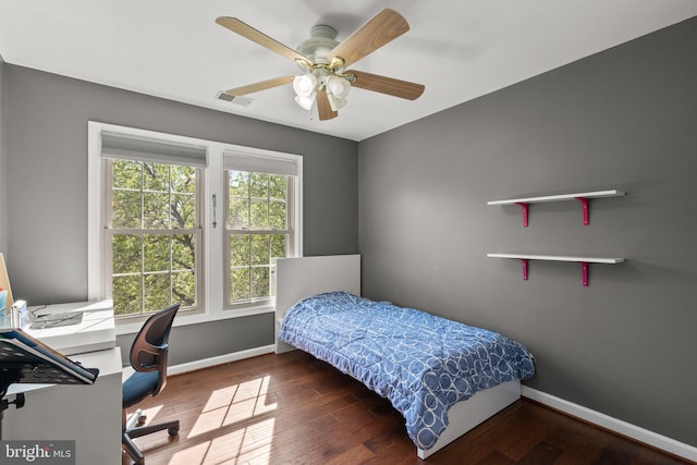 bedroom featuring visible vents, baseboards, a ceiling fan, and wood finished floors