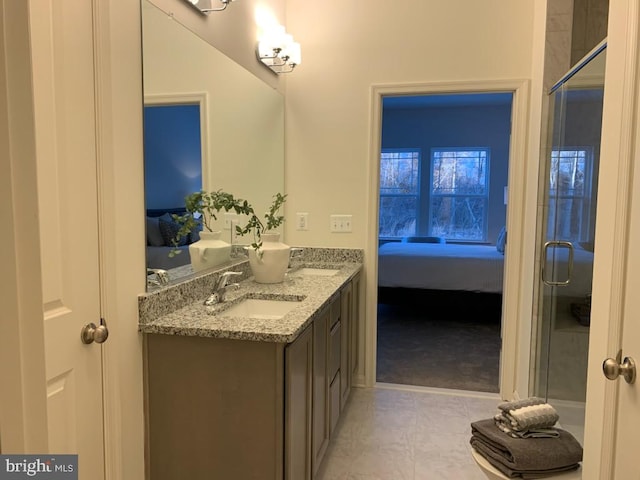 ensuite bathroom with double vanity, a shower with door, a sink, and ensuite bathroom