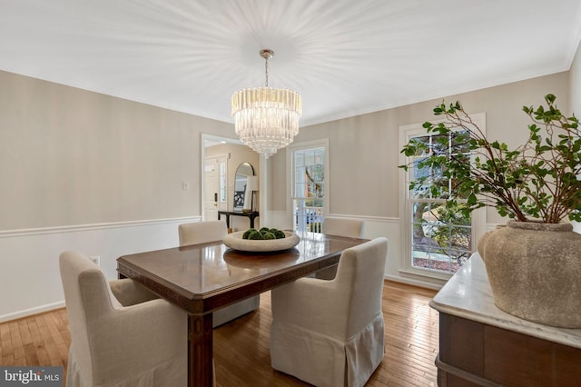 dining room with ornamental molding, hardwood / wood-style floors, and a chandelier