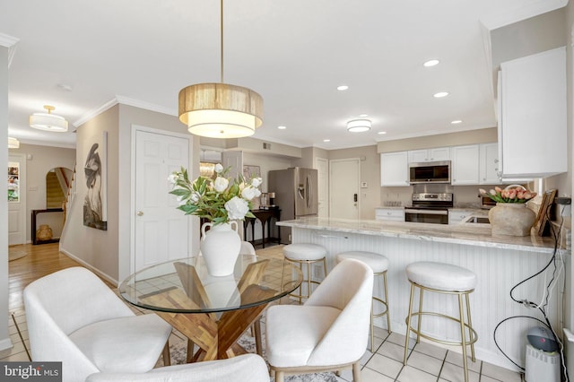 dining space featuring arched walkways, light tile patterned flooring, recessed lighting, baseboards, and crown molding