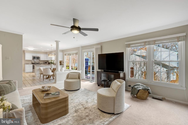 living area with crown molding, baseboards, and light colored carpet