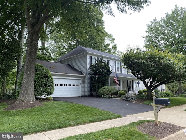 view of front of home featuring an attached garage, a front lawn, and aphalt driveway