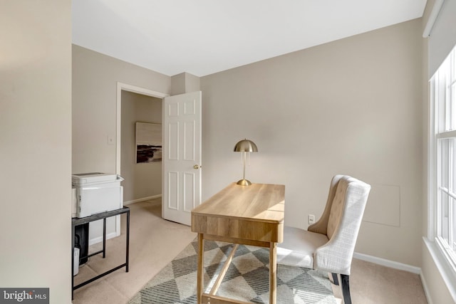 office area featuring light carpet and baseboards