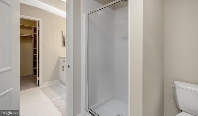 full bath featuring tile patterned flooring, a shower stall, toilet, and a spacious closet