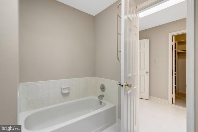 bathroom featuring a bath and baseboards