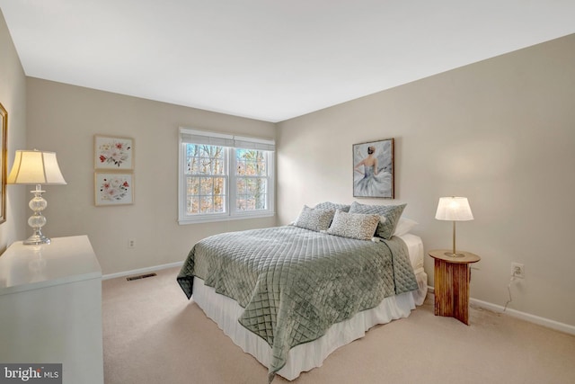 bedroom with light carpet, visible vents, and baseboards