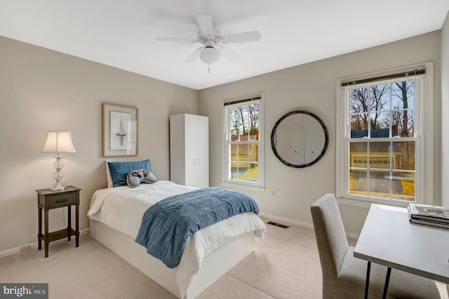 bedroom featuring multiple windows, visible vents, and light colored carpet