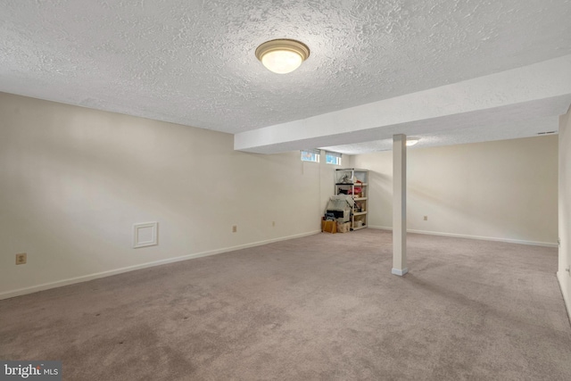 below grade area featuring carpet, a textured ceiling, and baseboards