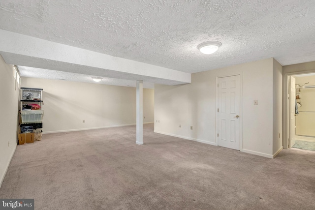 finished basement featuring carpet flooring, a textured ceiling, and baseboards