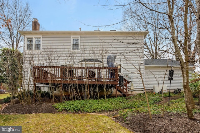 rear view of property featuring a chimney and a deck