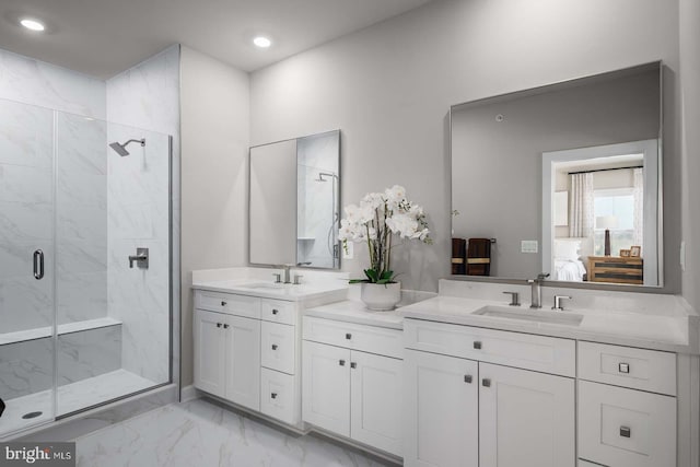 ensuite bathroom with a marble finish shower, ensuite bathroom, marble finish floor, vanity, and recessed lighting