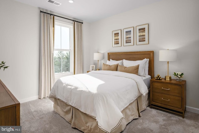 bedroom with light carpet, visible vents, and baseboards