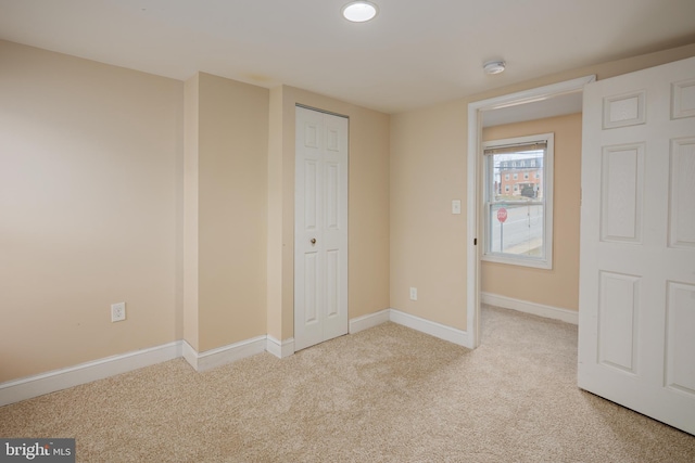 unfurnished bedroom with carpet floors, a closet, and baseboards