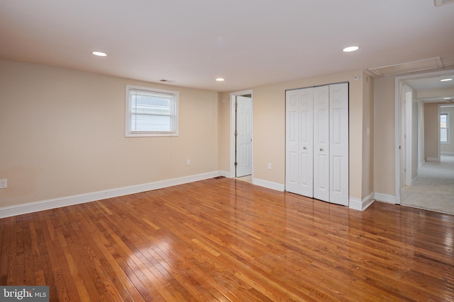 unfurnished bedroom with multiple windows, recessed lighting, hardwood / wood-style flooring, and baseboards