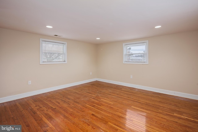 spare room featuring recessed lighting, baseboards, and hardwood / wood-style floors