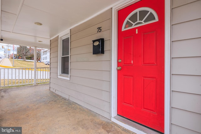 view of exterior entry featuring covered porch