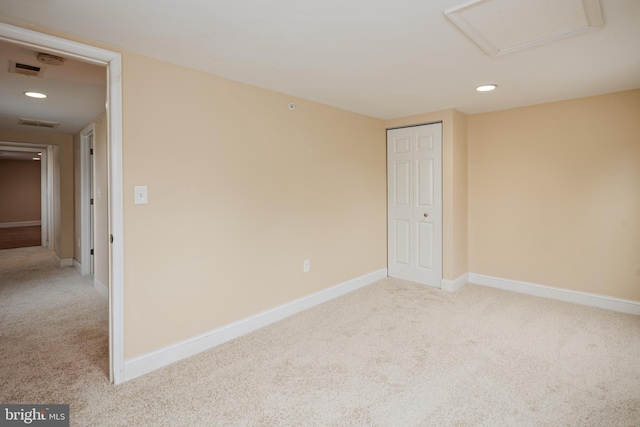 spare room featuring carpet, attic access, baseboards, and recessed lighting