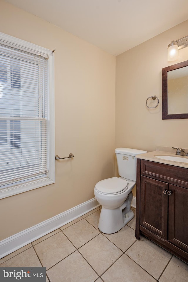 bathroom featuring vanity, tile patterned flooring, toilet, and baseboards