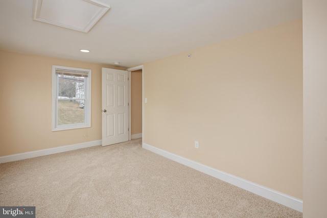 unfurnished room featuring recessed lighting, carpet flooring, attic access, and baseboards