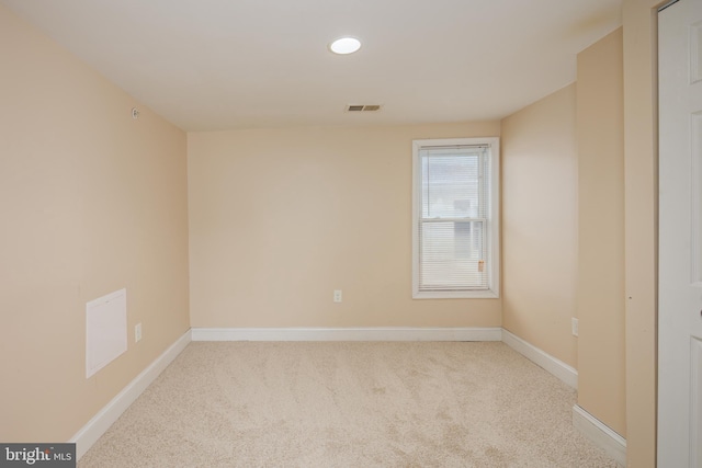 empty room featuring carpet, visible vents, and baseboards