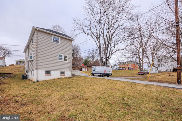 view of property exterior featuring central AC and a lawn