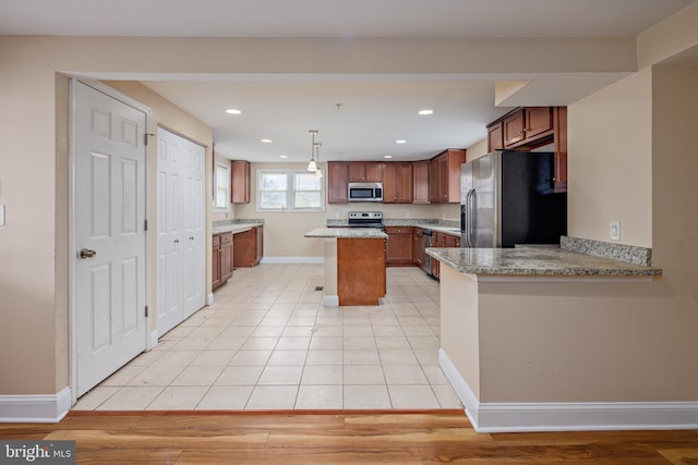 kitchen with light tile patterned floors, recessed lighting, baseboards, appliances with stainless steel finishes, and a center island