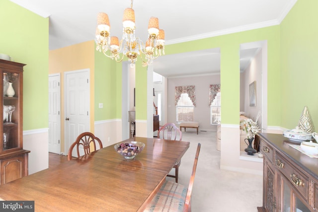 dining area featuring a notable chandelier, carpet, and ornamental molding