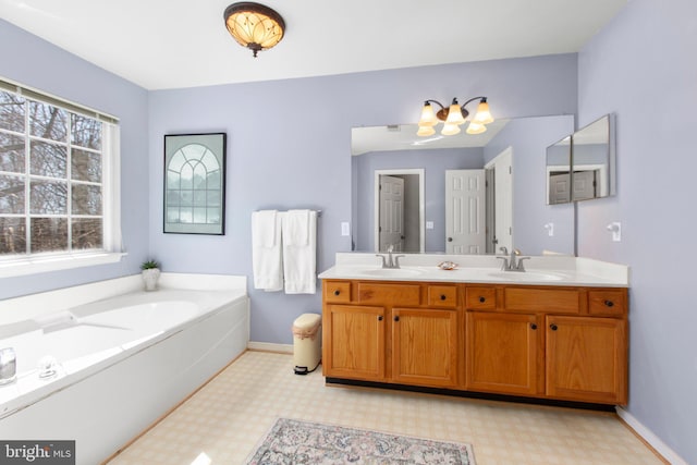 full bath with a sink, baseboards, double vanity, and tile patterned floors