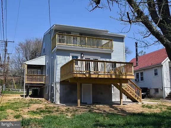 back of property featuring stairs and a balcony