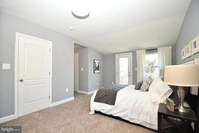 carpeted bedroom with access to exterior, lofted ceiling, and baseboards