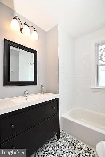 bathroom featuring toilet, shower / bath combination, vanity, and tile patterned floors