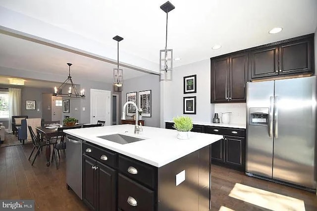 kitchen with dark wood-type flooring, stainless steel appliances, a sink, and light countertops