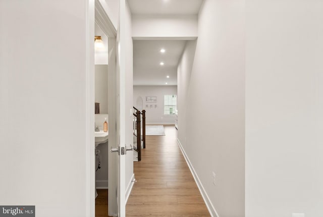 hallway with recessed lighting, wood finished floors, and baseboards