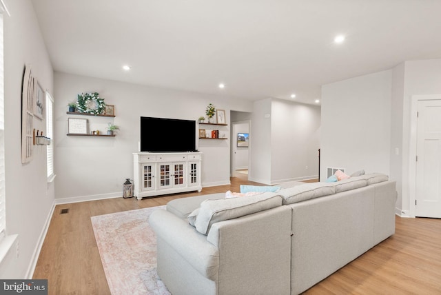 living area featuring light wood-style floors, visible vents, baseboards, and recessed lighting