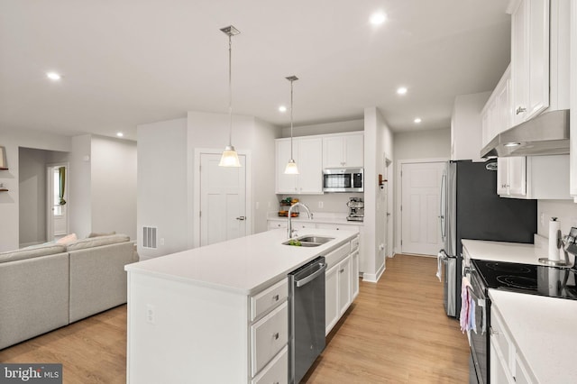 kitchen featuring visible vents, appliances with stainless steel finishes, white cabinetry, a sink, and under cabinet range hood