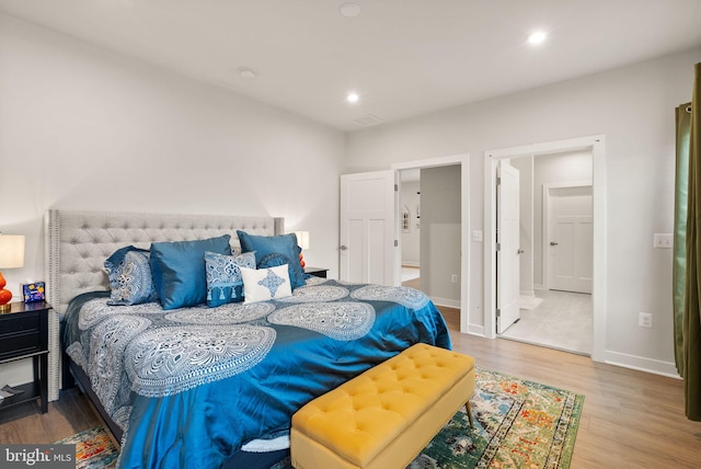 bedroom featuring baseboards, wood finished floors, and recessed lighting