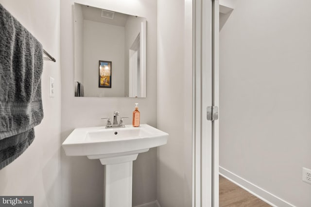 bathroom with wood finished floors, visible vents, and baseboards