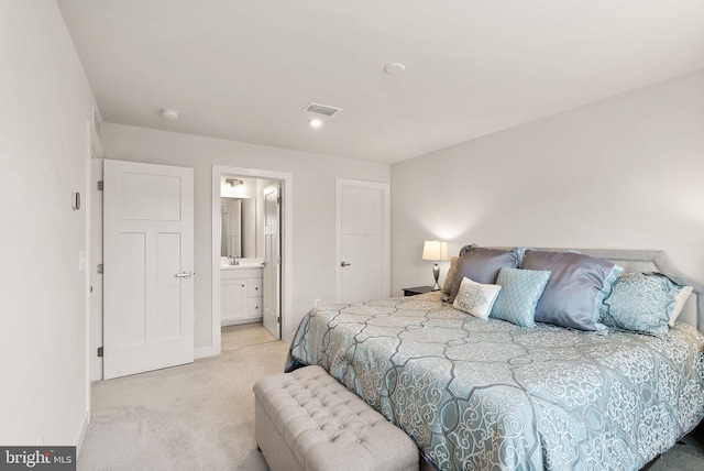 bedroom with baseboards, visible vents, ensuite bathroom, and light colored carpet