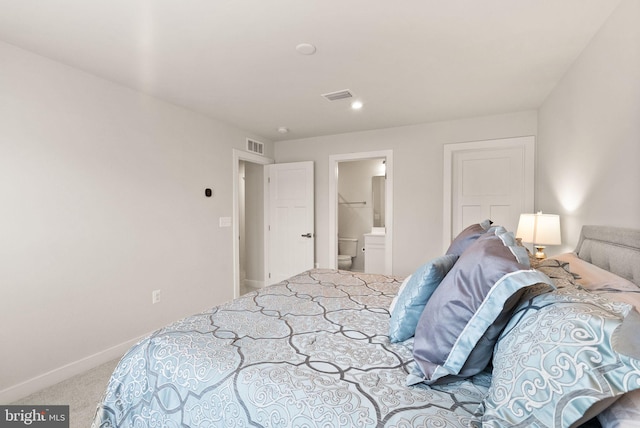 bedroom featuring ensuite bathroom, carpet floors, visible vents, and baseboards