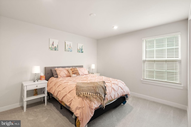 bedroom with baseboards and light colored carpet