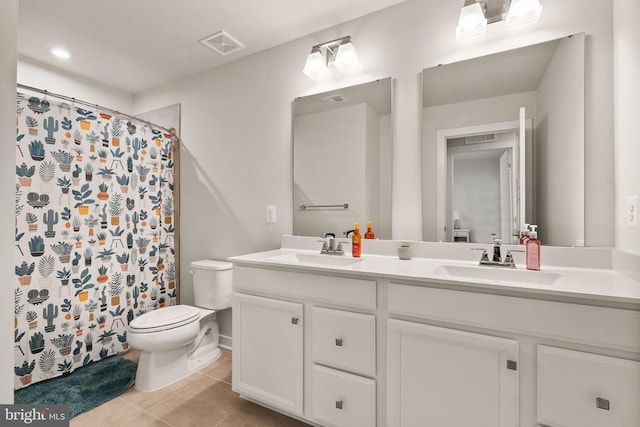 bathroom featuring toilet, visible vents, a sink, and tile patterned floors